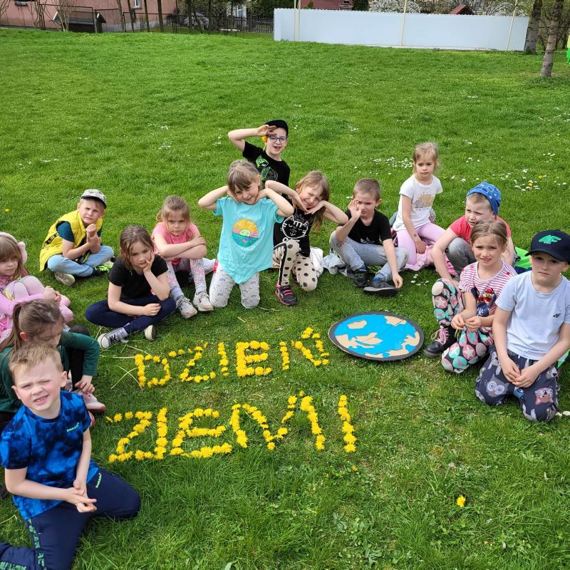 dzieci siedzą na trawie