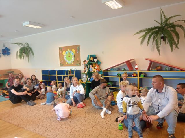 rodzice i dzieci bawia sie na dywanie