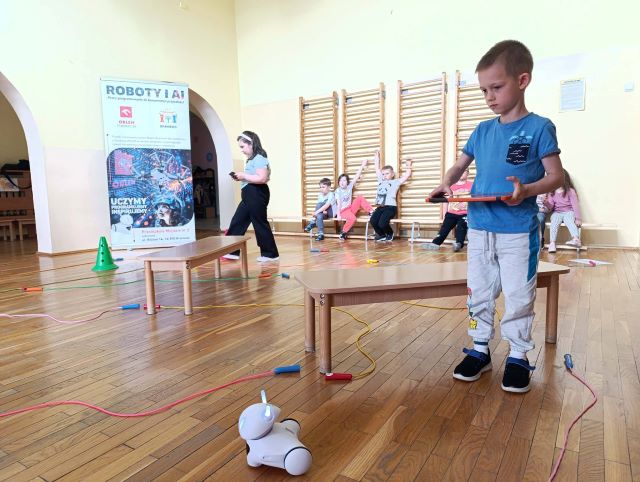 dziewczynka z chlopcem staruja robotemi
