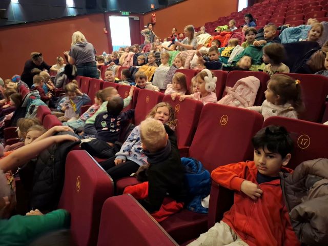 dzieci siedza na sali kinowej