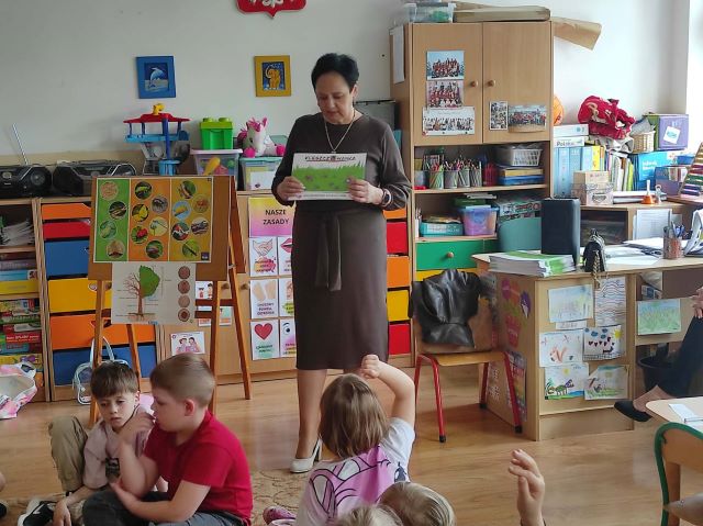 pani z sanepidu pokazuje ksiazke o myciu rak
