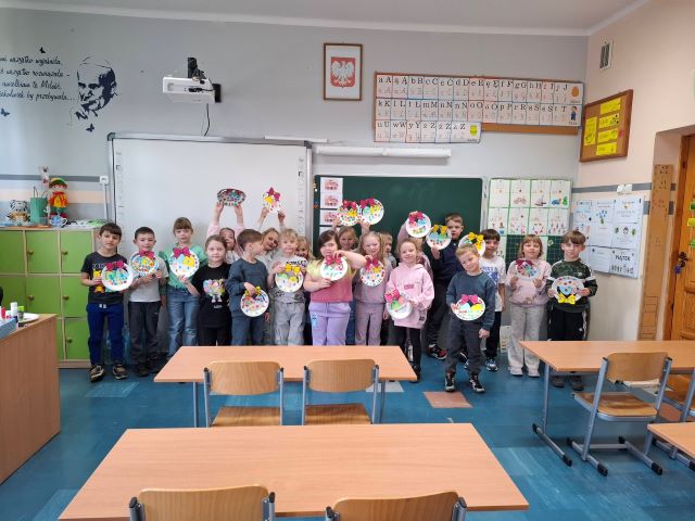 dzieci stoja z koszyczkami z papieru